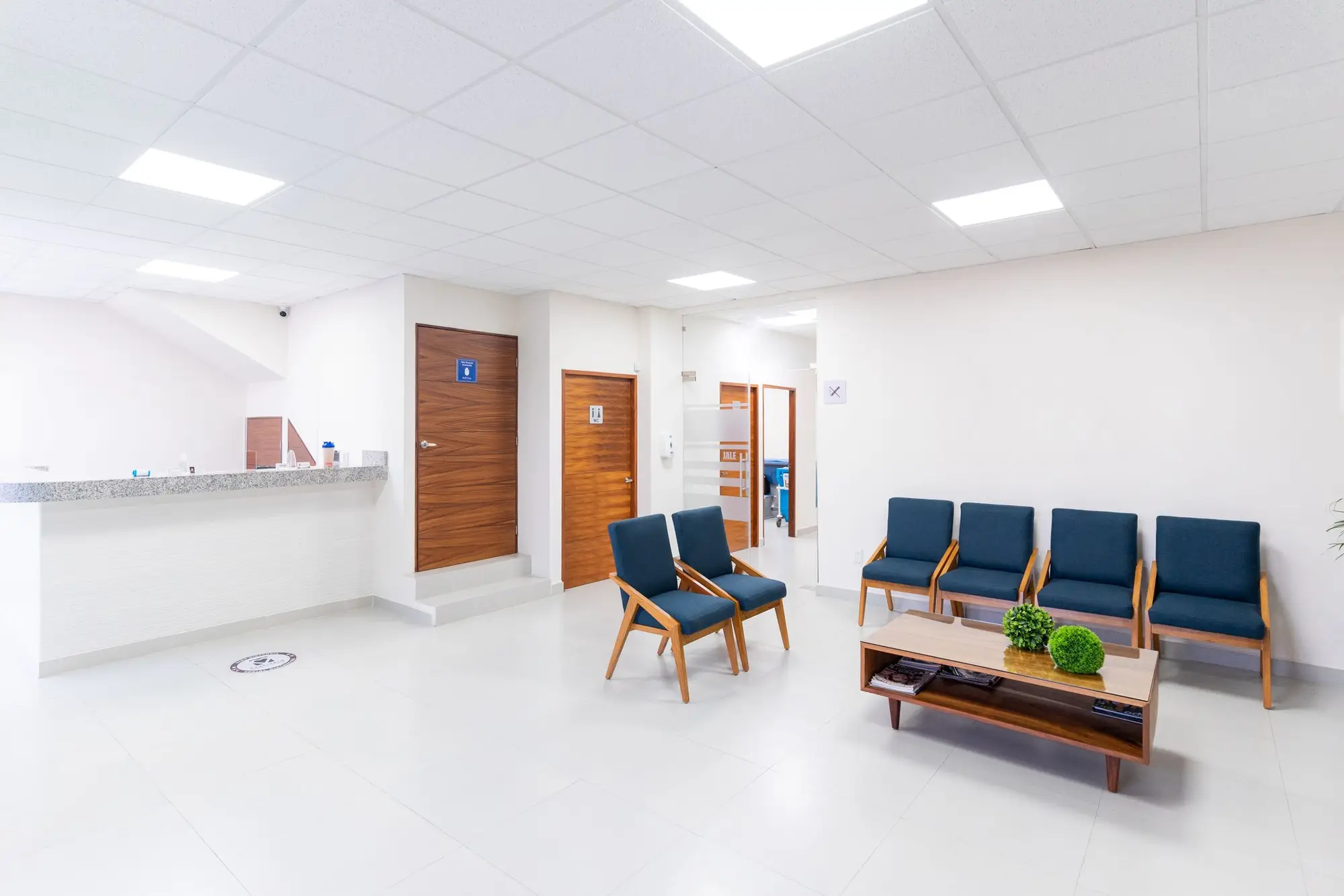 A bright clinic waiting room with empty chairs